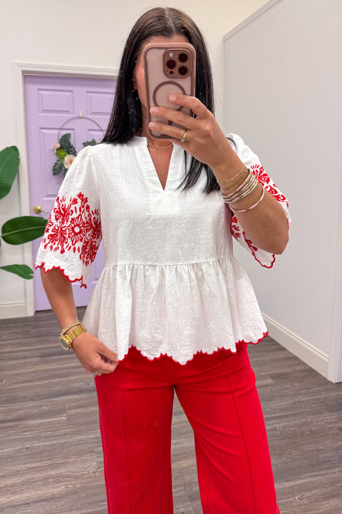 ivory scallop trim peplum top with red embroidered flower details