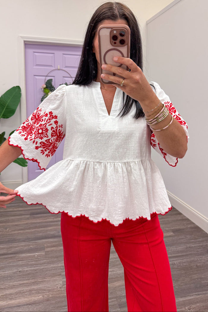 ivory scallop trim flowy peplum top with red embroidered flower details