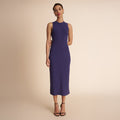 Woman wearing a sleeveless purple dress against a beige background | Lead