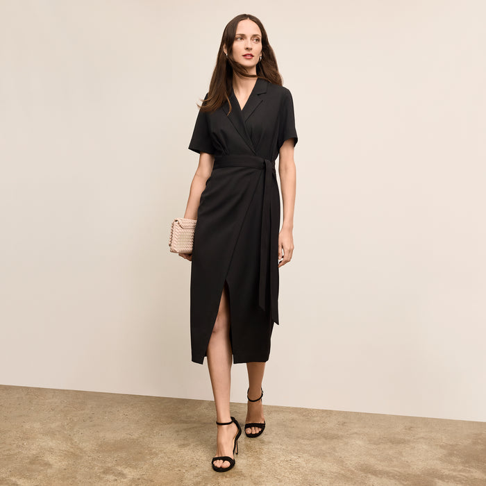 Woman wearing a black dress with a beige background | Lead