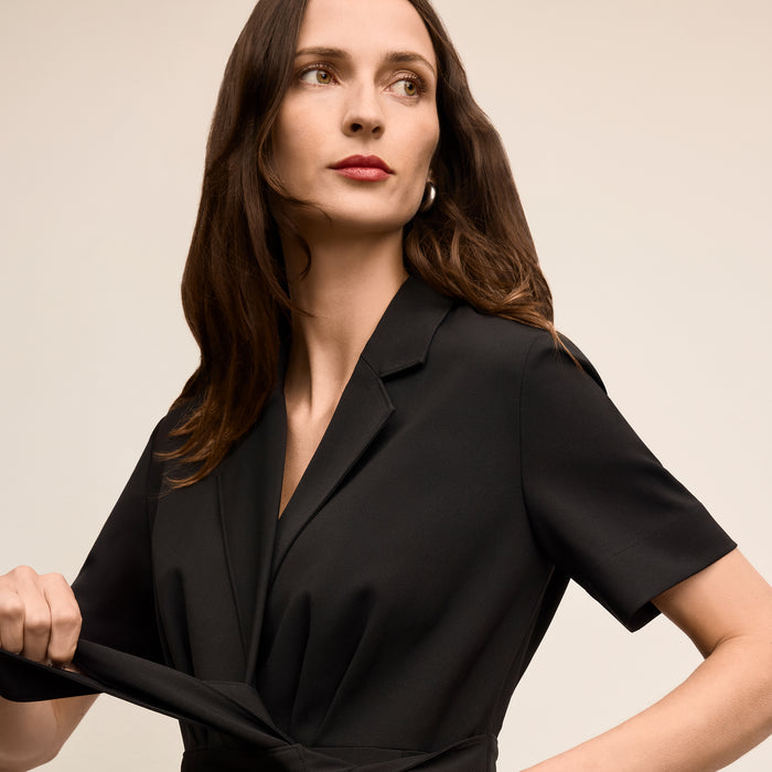 Woman wearing a black blazer against a neutral background