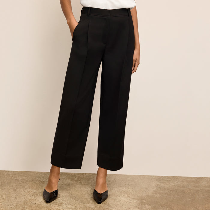 Person wearing black wide-leg pants against a beige background | Lead