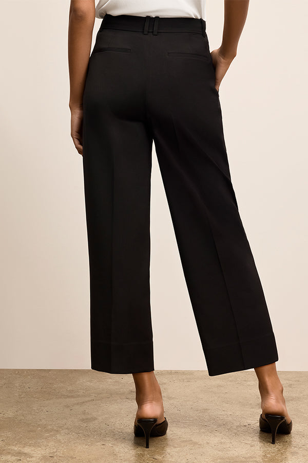 Person wearing black pants on a plain background | Exclude | Grid Hover