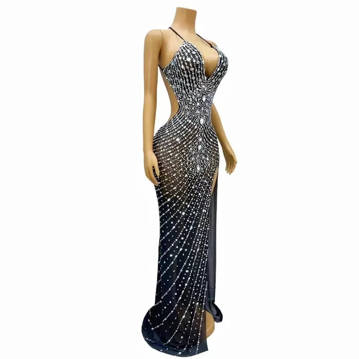 Elegant prom dress completely covered in silver rhinestones with a dramatic high split. Audre sparkling formal gown.