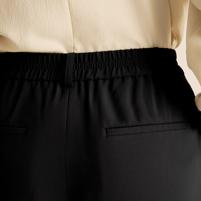 Black pants with a beige top in a close-up shot