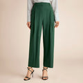 Green pants worn with a striped shirt on a beige background | Lead