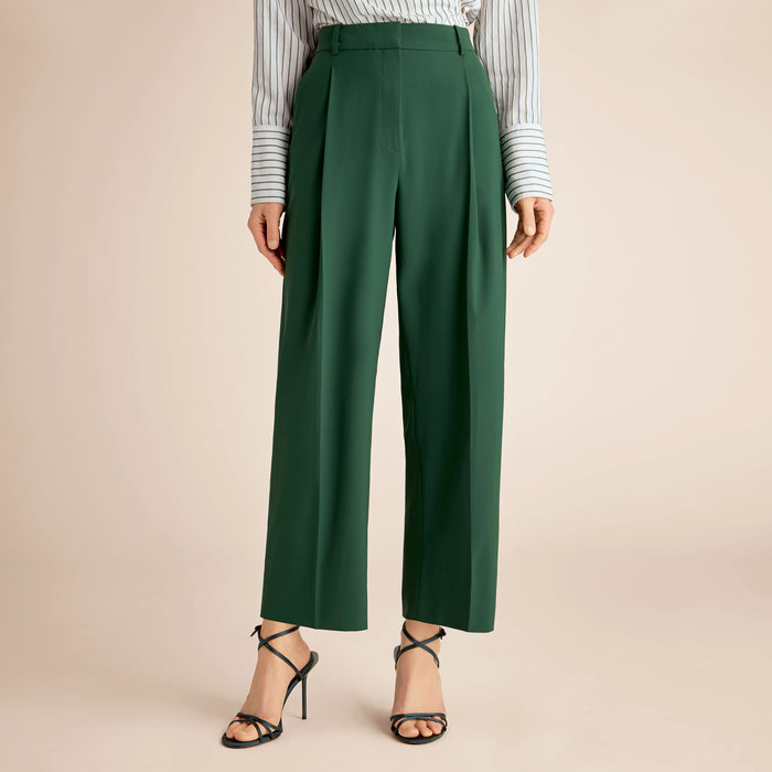 Green pants worn with a striped shirt on a beige background | Lead