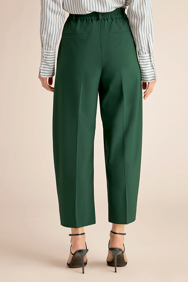 Green pants worn with a striped shirt on a beige background | Exclude