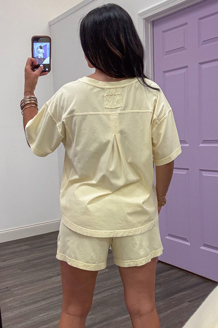 solid washed butter yellow short sleeve crew neckline knit top with back pleated detail