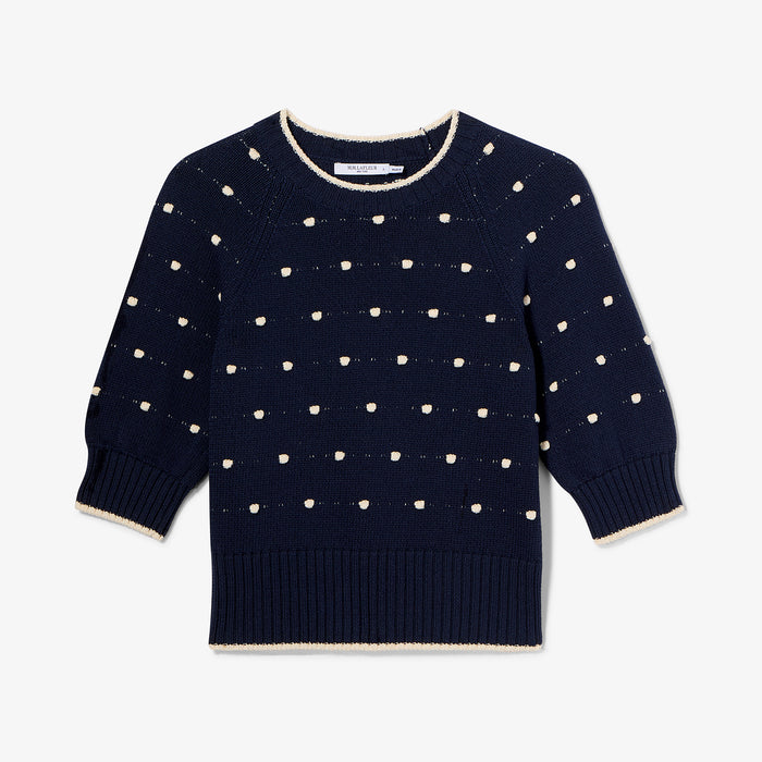 Navy sweater with white dot pattern on a light gray background