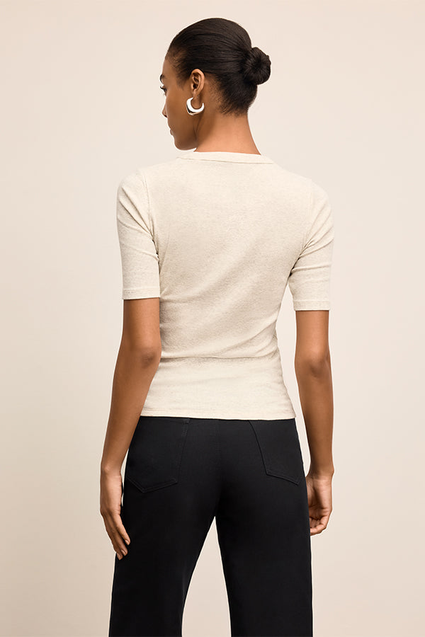 Person wearing a white short-sleeve shirt and black pants on a beige background | Exclude | Grid Hover