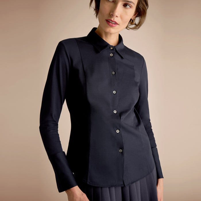 Woman wearing a black blouse against a beige background