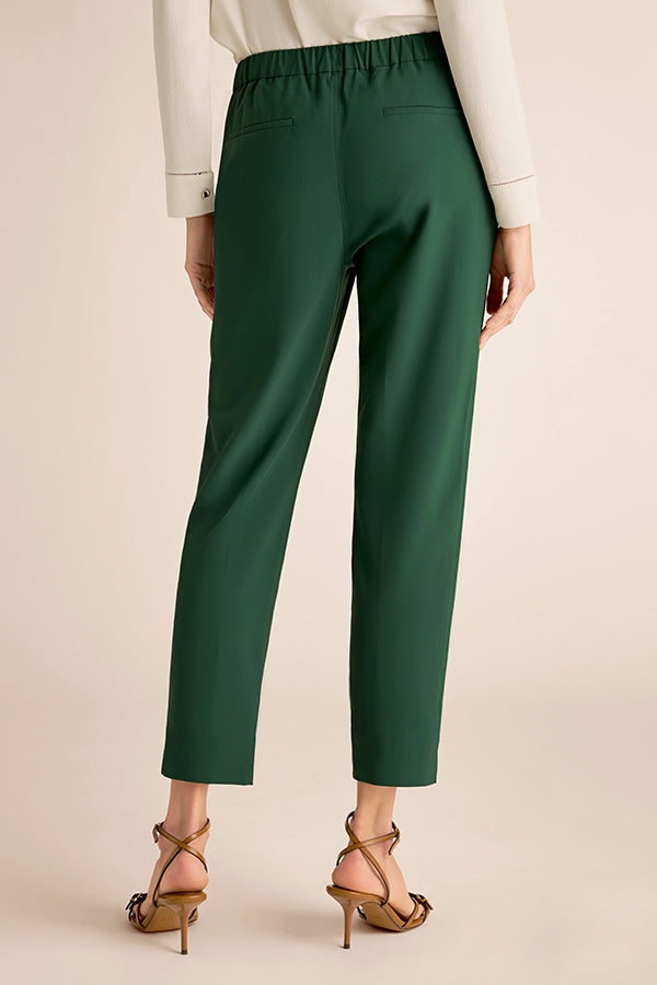 Green pants worn by a person on a beige background | Exclude | Grid Hover