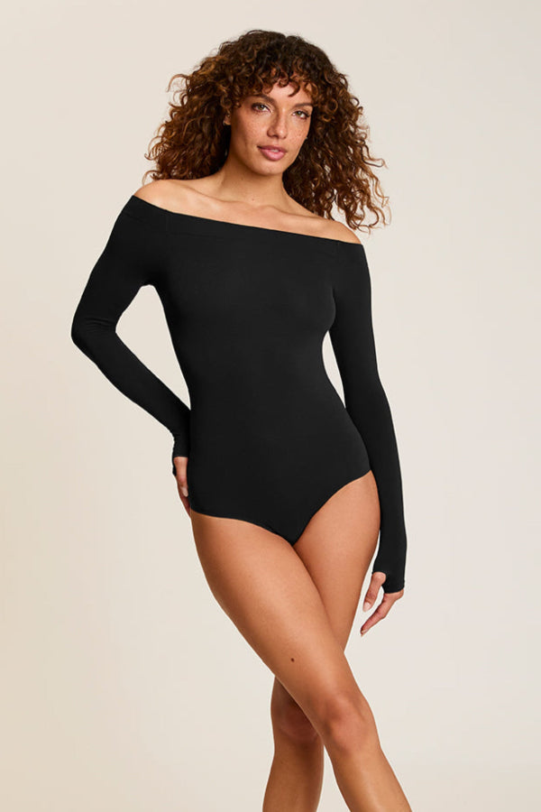 Woman wearing a black off-shoulder bodysuit against a beige background | Grid Hover | Exclude