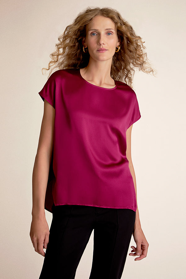 Woman wearing a magenta top against a beige background | Grid | Exclude