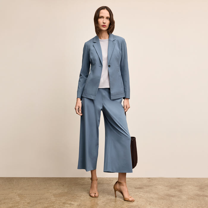 Woman wearing a blue suit with a beige background