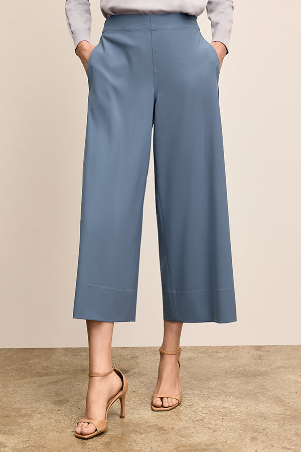 Blue wide-leg pants worn by a person on a beige background | Grid | Exclude