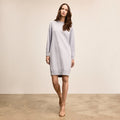 Woman wearing a light gray dress against a plain background | Lead