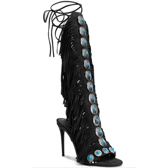Black fringe knee high boots with cross straps and stiletto heels.