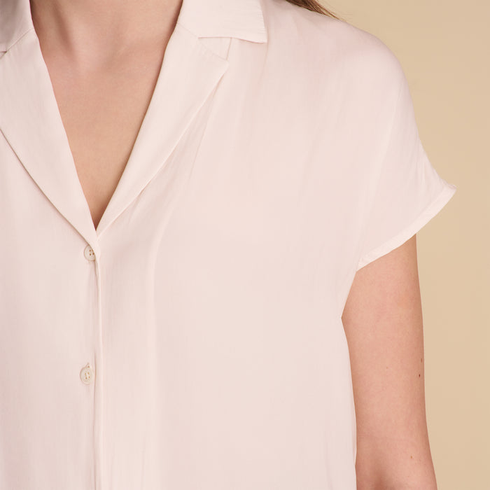 woman in white blouse on beige background.
