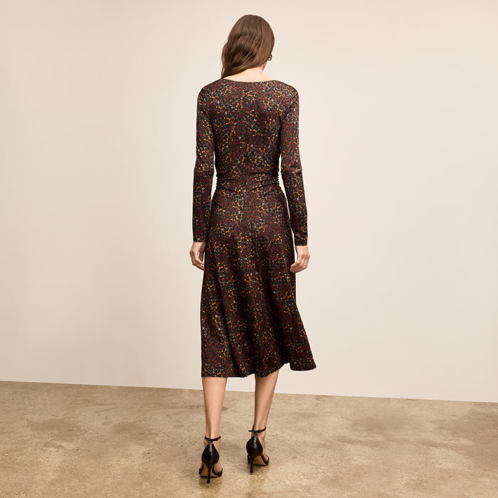 Woman wearing a patterned dress against a plain background