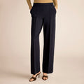 Navy blue pants worn by a person on a beige background | Lead