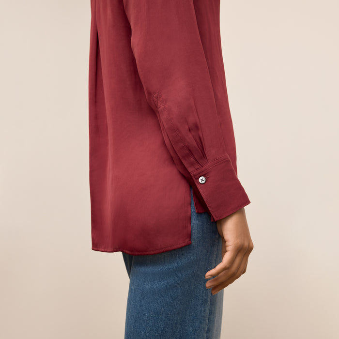 Red shirt worn by a woman on a beige background
