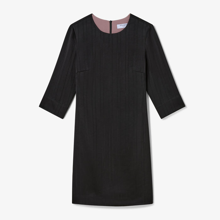 Black dress with pink lining on a white background
