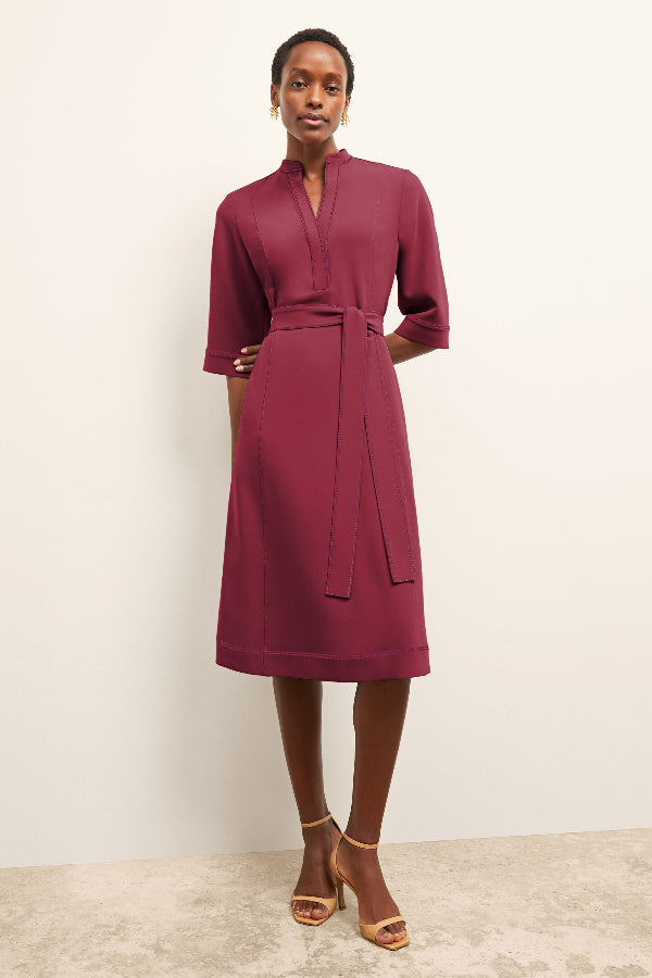 Woman wearing a burgundy dress against a plain background | Grid | Exclude