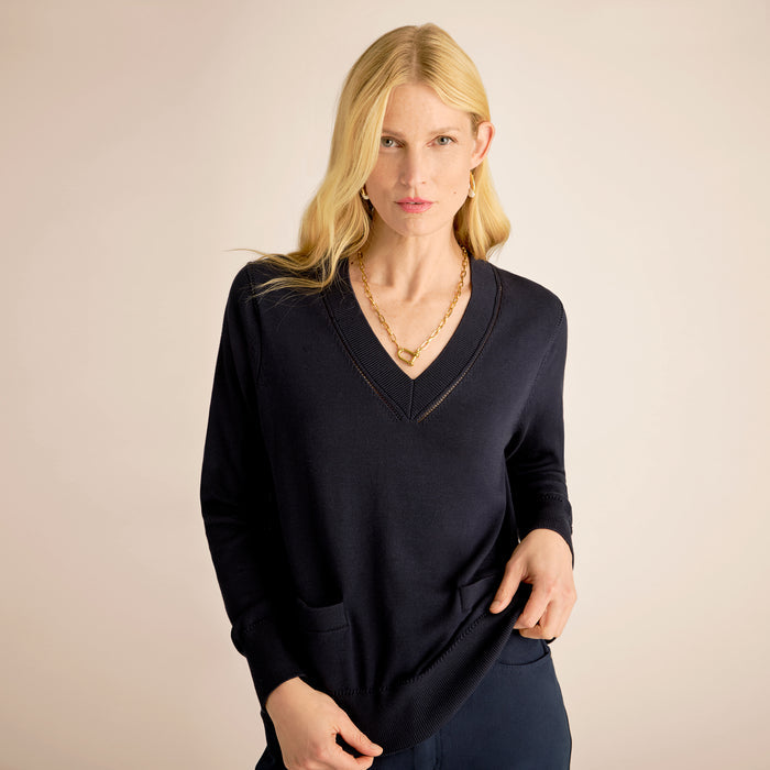 Woman wearing a black sweater against a beige background | Lead