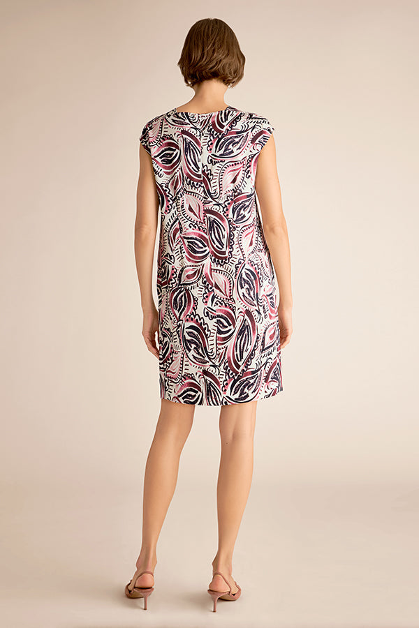Woman wearing a patterned dress on a beige background | Exclude