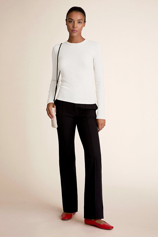 Woman wearing a white top and black pants | Grid | Exclude