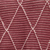 Close-up of a textured fabric with a geometric pattern in red and pink. | Exclude | Swatch