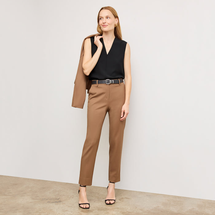 Front image of a woman standing wearing the Mejia pant in camel |
