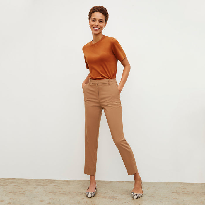 Front image of a woman standing wearing the Mejia pant in camel | Exclude