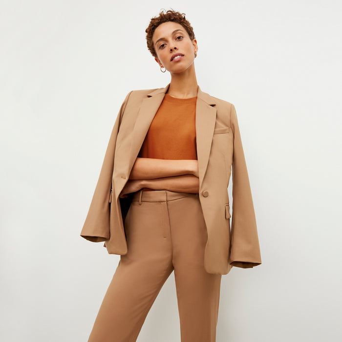 Front image of a woman standing wearing the Mejia pant in camel | Exclude