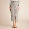 Person wearing a patterned skirt on a beige background | Lead