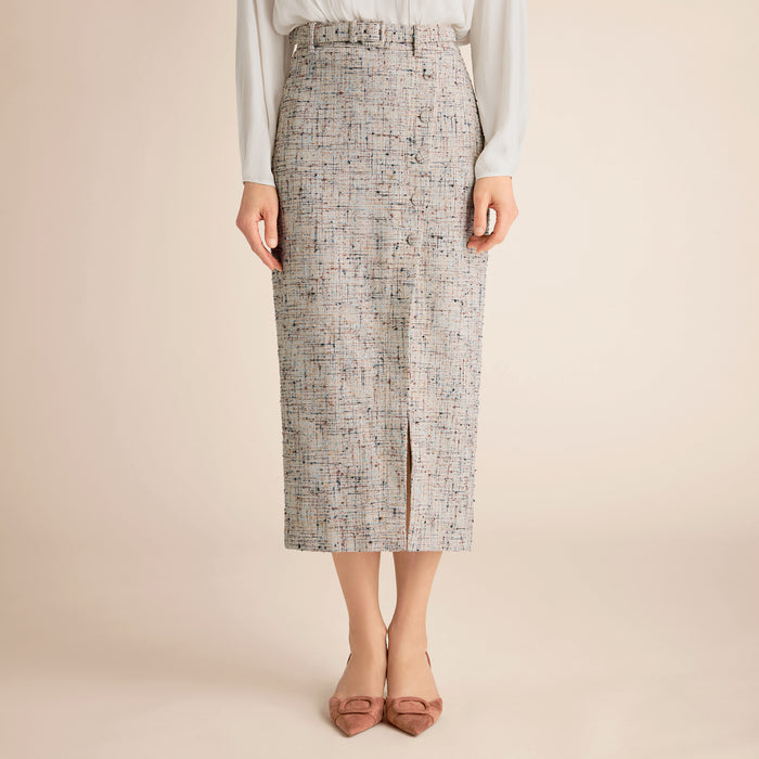 Person wearing a patterned skirt on a beige background | Lead
