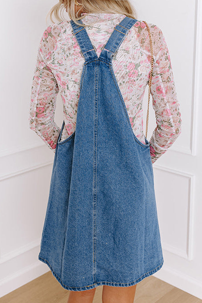 Mini-robe en jean bleu crépuscule à larges bretelles boutonnées avec poches sur le devant