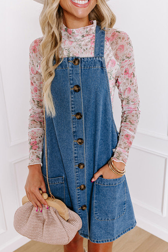 Mini-robe en jean bleu crépuscule à larges bretelles boutonnées avec poches sur le devant