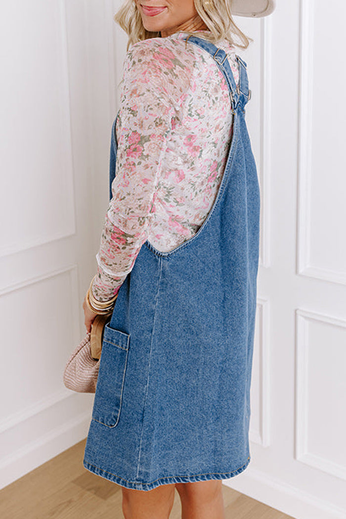 Mini-robe en jean bleu crépuscule à larges bretelles boutonnées avec poches sur le devant