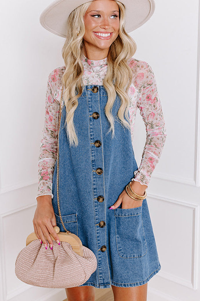 Mini-robe en jean bleu crépuscule à larges bretelles boutonnées avec poches sur le devant