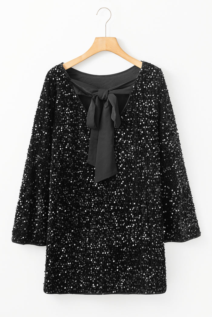 Mini-robe noire à paillettes et manches longues avec nœud découpé dans le dos