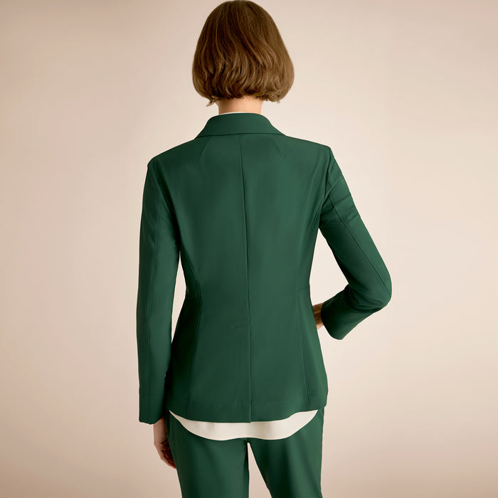 Green suit worn by a person on a beige background