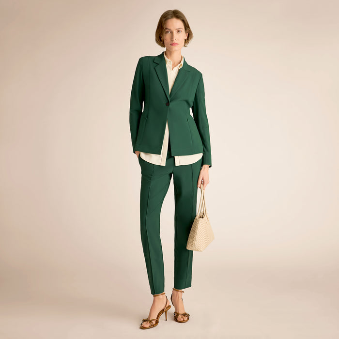 Woman wearing a green suit with a beige background