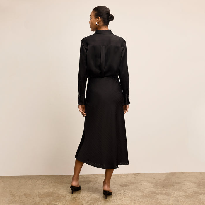 Woman wearing a black dress against a plain background