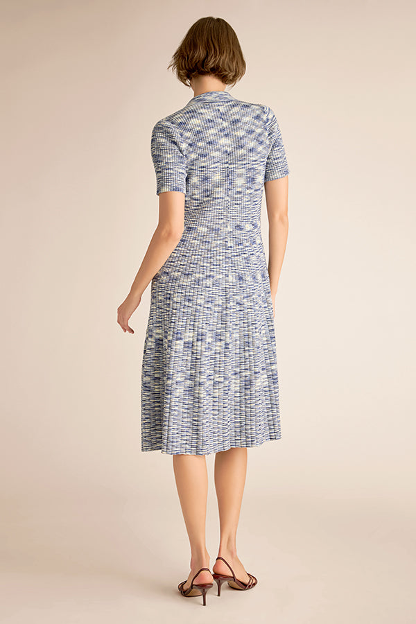 Woman wearing a blue patterned dress on a beige background | Exclude