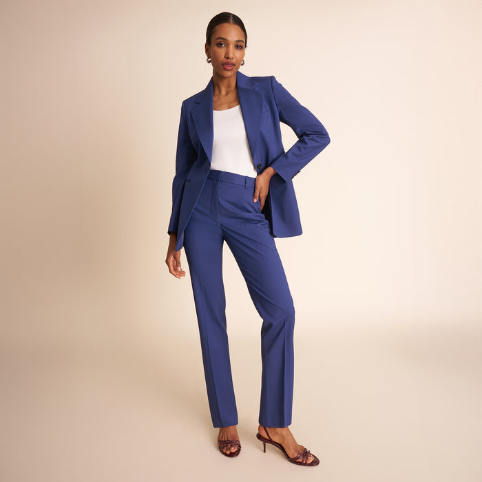 Woman in blue blazer and pants and white top.