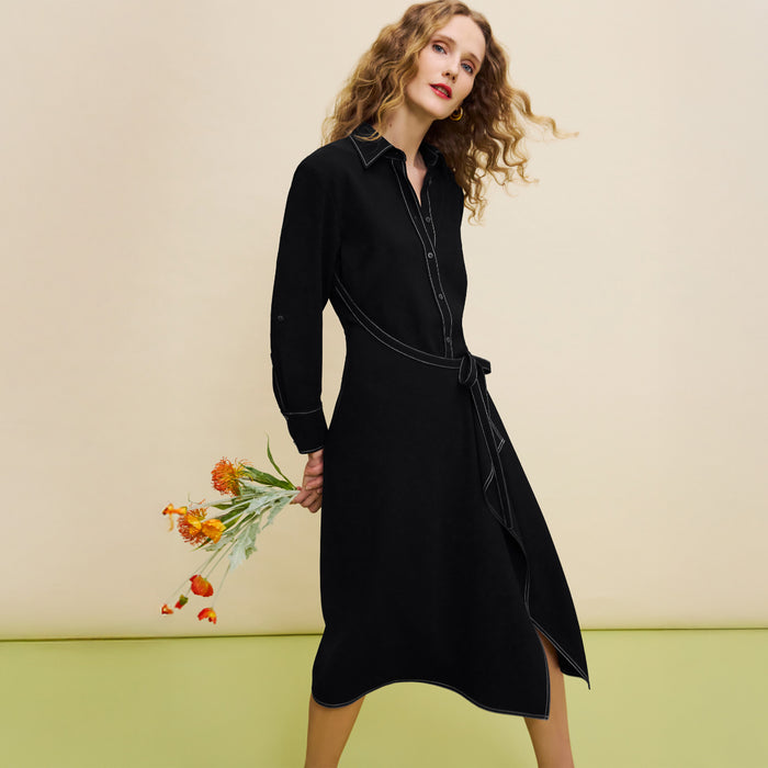 Woman wearing a black dress holding flowers against a beige background | Lead