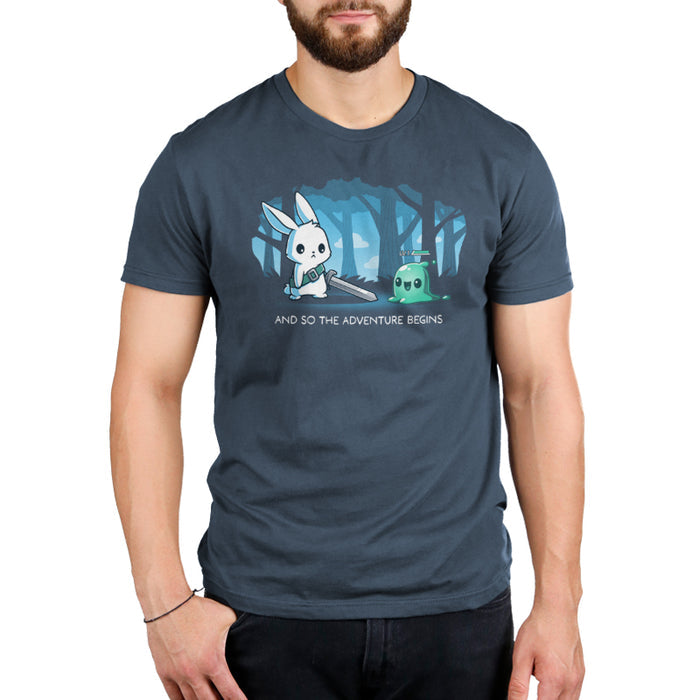 Premium Cotton T-shirt_TeeTurtle The Adventure Begins denim blue t-shirt featuring a cartoon rabbit brandishing a sword facing a small green slime creature labeled 'LV.1' in a forest. The text below reads, "AND SO THE ADVENTURE BEGINS."